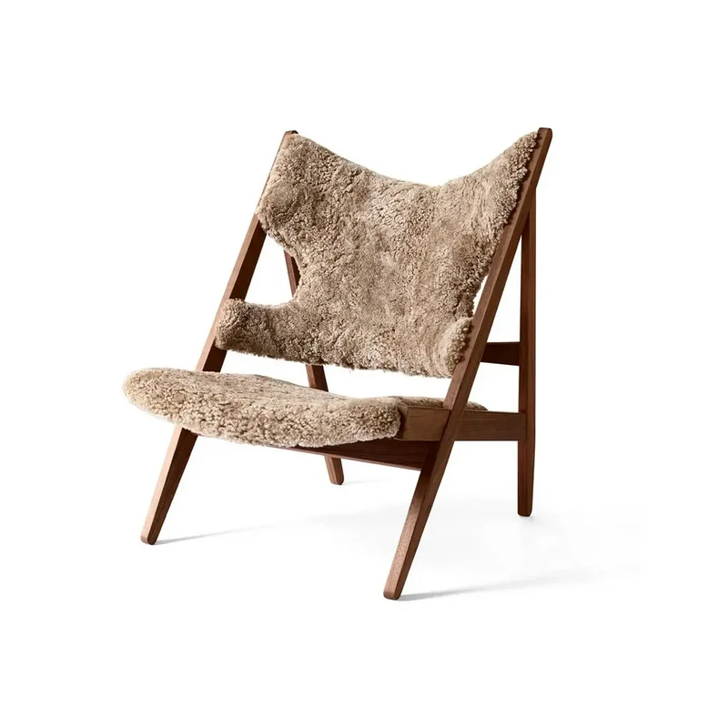 A cozy Sheepskin Knitting Accent Chair featuring a plush, textured beige fleece seat on a minimalist natural wood frame.