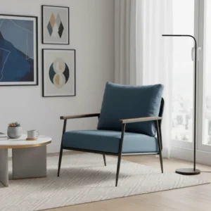 Blue upholstered lounge chair with wooden arms in a bright, modern living room, beside a round coffee table and a tall arching floor lamp and framed wall art.