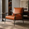 Brown leather armchair with a black metal frame in a modern living room setting on a textured rug.
