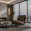 Contemporary living room with a gas fireplace, tall plant, and floor-to-ceiling windows overlooking a city skyline; tan lounge chair and round coffee table on a textured rug.