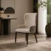 Cream upholstered high-back chair with quilted side panels in a modern living room setting