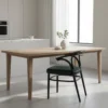 8-24990 Minimalist kitchen/dining area with a light wood table, black curved chair with a green cushion, and a plant on the table near a window.