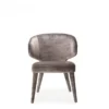 Gray velvet upholstered chair with a rounded back and tapered legs, shown from the front
