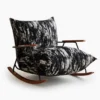 Rocking chair with black-and-white textured upholstery, wooden armrests, and curved wooden rockers.