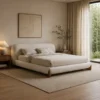 Neutral, minimalist bedroom with a low, cream upholstered bed flanked by wooden nightstands and soft lighting.
