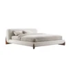 2-96458 Modern low-profile bed with a curved beige headboard and light bedding.