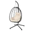 Hanging egg chair with beige cushions and pillow on a black metal stand set against a white background.