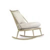 Gold-toned metal rocking chair with light gray cushions on a white background.