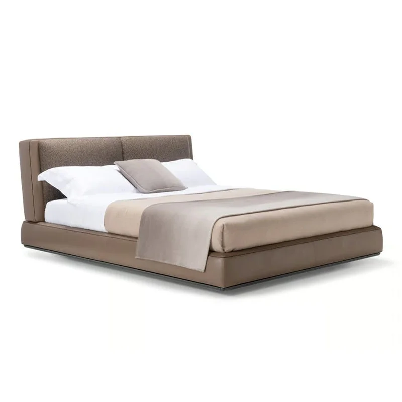 Platform bed with a tan upholstered headboard and base, white sheets, and beige throw blanket.