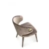 Velvet upholstered curved lounge chair with a rounded back and gold button accent on the side.