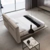 Modern minimalist bedroom with a low upholstered bed, white bedding, and a dark throw; large windowed wall and neutral tones throughout.