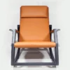 Front view of an orange leather lounge chair with a metal frame, padded headrest visible, single-seat armchair design.