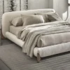 5-96458 Neutral-toned upholstered bed with rounded headboard and low-profile footboard on a striped rug.
