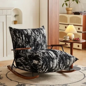 A stylish black-and-white patterned rocking chair with wooden arms in a cozy living room, next to a round side table with a lamp and cup of tea.