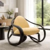 Contemporary mustard-yellow upholstered lounge chair with a black sculptural frame in a bright living room.