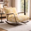 Yellow and white patterned lounge chair with wooden rockers in a bright living room by a window and side table with a lamp and decor.