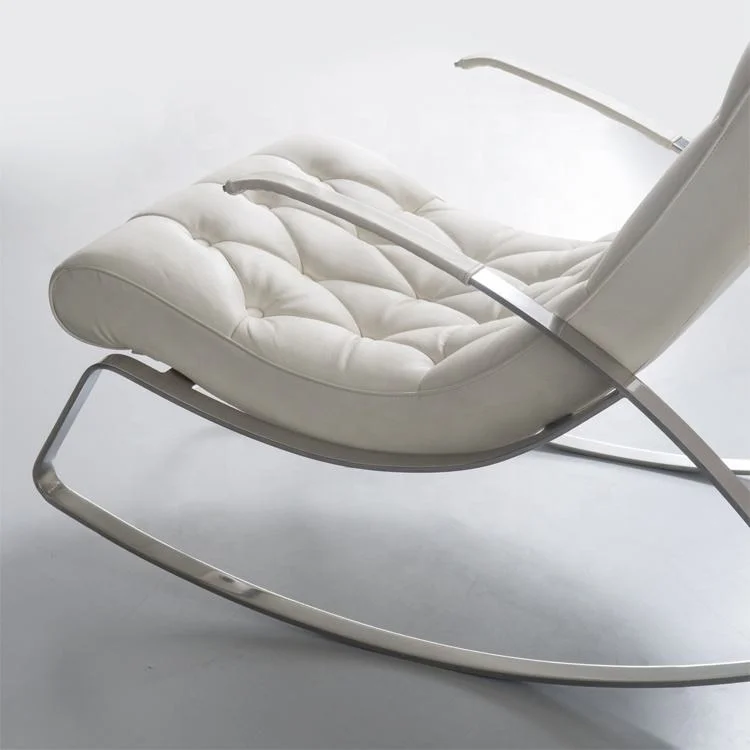 White tufted leather lounge chair with a curved metal base and minimalist frame, angled backrest for reclined seating.