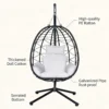 Egg-shaped outdoor hanging chair with white cushions on a metal stand, ready for use. (informational product image)