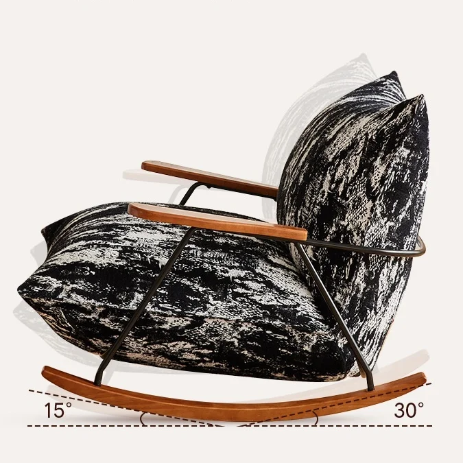 Rocking chair with wooden arms and a black‑white patterned cushion, tilted on curved wooden rockers showing a rocking angle.