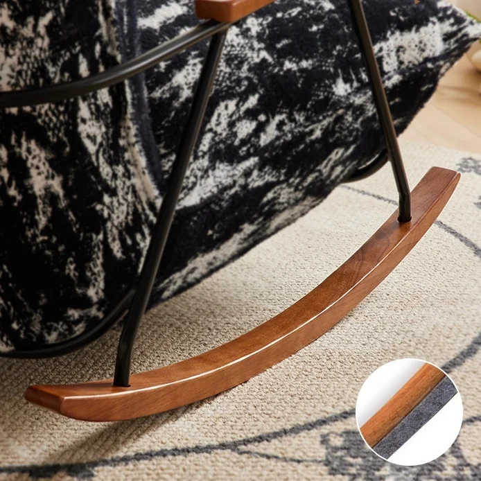 Wooden curved rocker foot with black metal frame on a beige rug; circular inset shows a close-up of the wood edge.