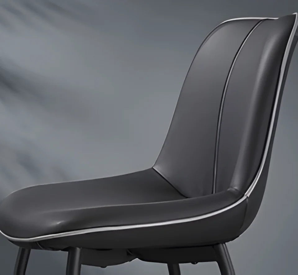 Gray upholstered chair with light piping along seams, close-up profile view.