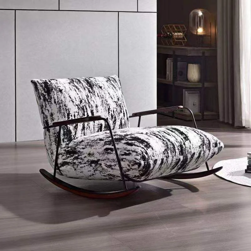 Modern rocking chair with black-and-white patterned upholstery in a minimalist living room.